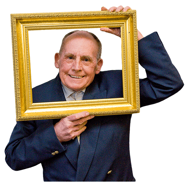 A person holding a frame and smiling