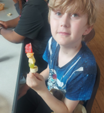 child holding fruit stick