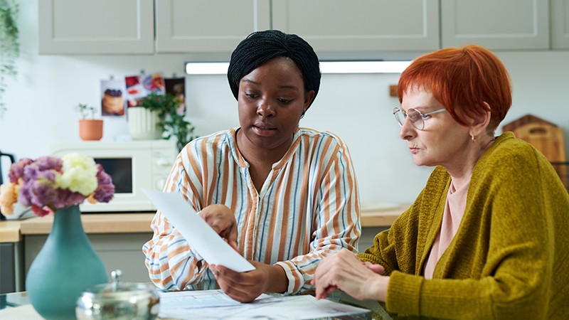 A staff member assisting a person with reading a document