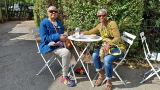 Two people sitting round a table outside