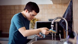 A person cleaning dishes in a sink