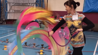 Image of person peforming chinese ribbon and fan dancing