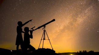 Image of two people using telescopes for stargazing